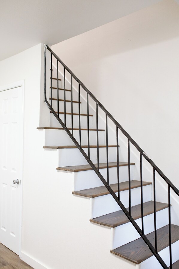 A staircase with wooden steps and black metal railings.