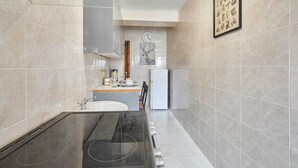 Eine moderne Küche mit einem Gasherd, einer Spüle und einem Kühlschrank.