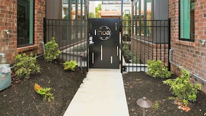 A brick building with a central pathway leading to a black gate.