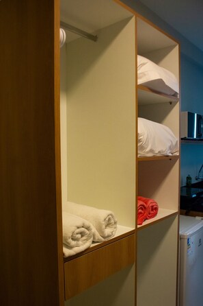 Ein Stockbett mit weißen und roten Handtüchern, einer Mikrowelle und einem kleinen Kühlschrank.