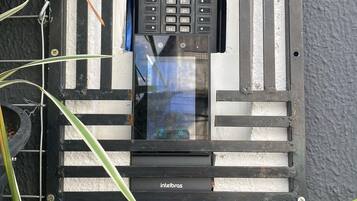 Una ventana con un teclado de seguridad y un pequeño macetero con una planta.