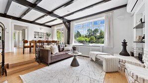 A spacious living room with a large window, a fireplace, and a cozy seating area.