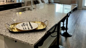 A kitchen with a granite countertop, a gold tray with cutlery, and a wine glass. - Olympus loft 2. Lovely apartment with fitness room and AC in Chandler (Chandler)
