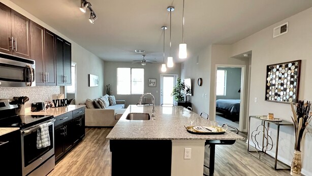 A modern kitchen with a central island, stainless steel appliances, and pendant lighting. - Olympus loft 2. Lovely apartment with fitness room and AC in Chandler (Chandler)