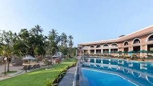 A hotel with a swimming pool, palm trees, and a well-maintained lawn. - Araliya Beach Resort & Spa Unawatuna- Where You Meet the Sea All Year (Unawatuna)