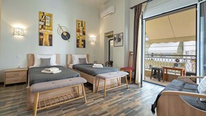A modern hotel room with two beds, a balcony, and artwork on the walls.