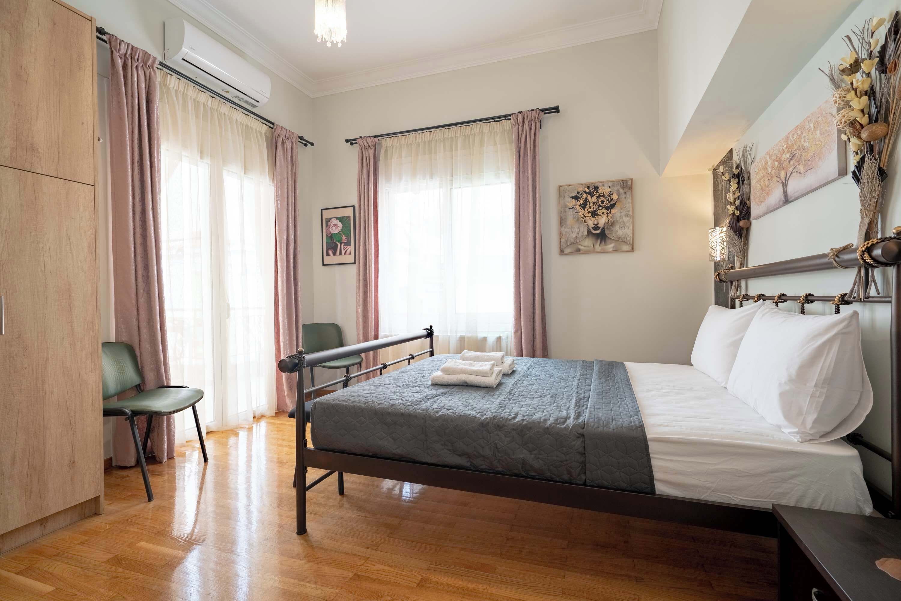 Un dormitorio con cama, una silla, un escritorio y un armario.