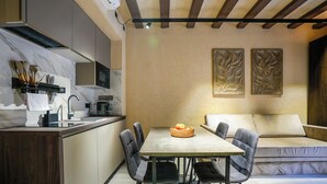 A modern kitchen with a dining area, featuring a marble backsplash, a built-in oven, and a dining table with chairs. - SJ7 Aparthotel (Sant Feliu de Guíxols)