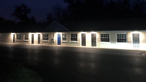 A two-story building with a flat roof, multiple windows, and a central door.