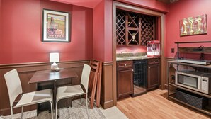 A compact kitchen with a dining area, a microwave, a wine cooler, and a framed picture on the wall. - Private Guest Suite in Beautiful Kirkland, West of Market neighborhood. (Kirkland)