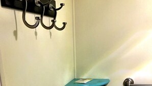 Une salle de bain avec un mur blanc, un porte-serviettes noir et un autre porte-serviettes bleu.