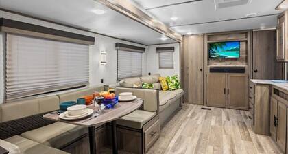 Super- fun camper with plenty of room for a full-size family, lots of comfy beds + full kitchen, bath, and separate bedroom for Mom & Dad. There's even a nice patio with outdoor kitchen and seating area for barbecues, bacon & eggs in the morning, et