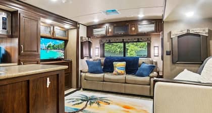 Spacious luxury RV with large kitchen/living room area, private bedroom w/king-size bed, bath and 1/2, with a deck, located in a beautiful RV resort with tons of amenities. Min. stay is 2 nights w/weekly and monthly discounts. Monthly rate is $1,600