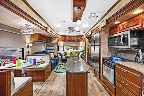 THIS IS AN AWESOME 36' RENTAL CAMPER WITH AMAZING LONG DECK, PLUS A SECOND STEP-DOWN DECK TO YOUR OWN PRIVATE HIDEAWAY TIKI BAR!  A BEAUTIFUL HUGE LIVE OAK COVERS THE ENTIRE LOT SO IT'S ALWAYS SHADED, AND THIS EVEN COMES WITH A TABLE & CHAIRS FOR OUT