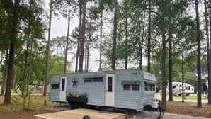 A mobile home with a star emblem, a ramp, and a small garden.