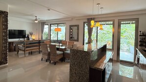 Una sala de estar moderna con comedor, ventanas amplias y cocina.