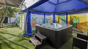A hot tub under a blue canopy with a mural of sea creatures on the walls. - Trendy & Relaxing: Close to Beach ~ Pool ~ Hot Tub (Sarasota)