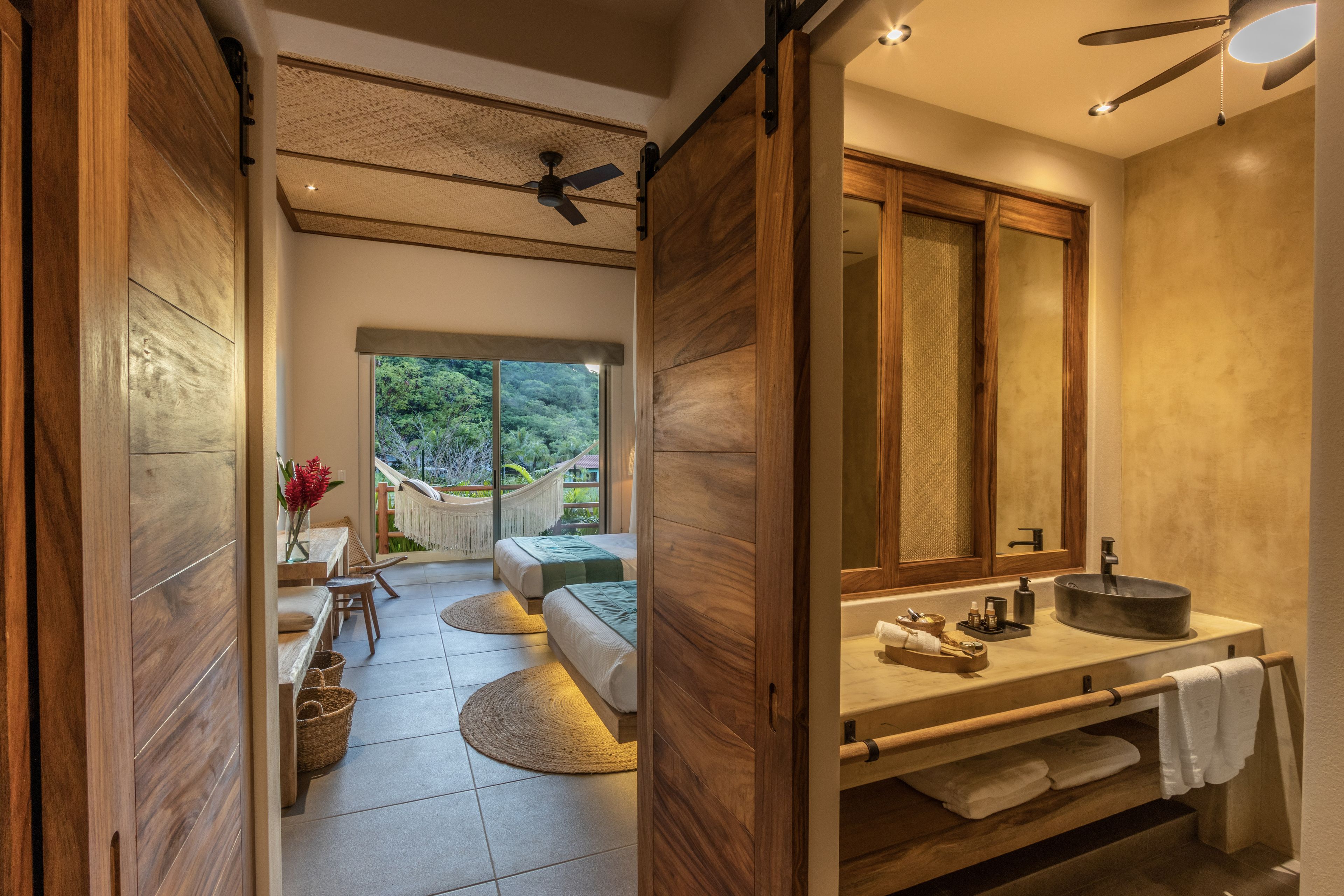Un baño moderno con un espejo grande, muebles de madera y un lavabo redondo.