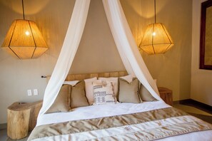 A bed with a canopy, two bedside lamps, and a wooden stool. - Casa Bocana Huatulco (Santa María Huatulco)