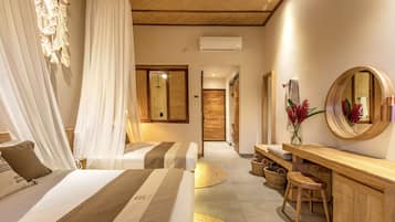 A modern hotel room with two beds, a wooden vanity, a mirror, and a small seating area.