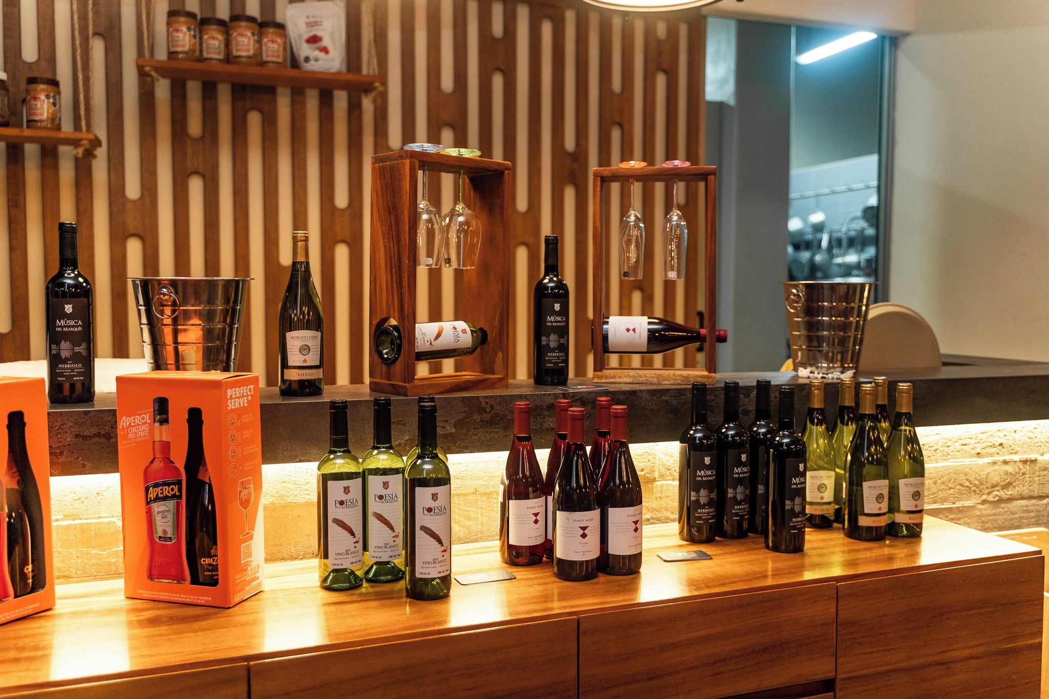 A wine bar with various bottles and glasses displayed on wooden shelves and counters.