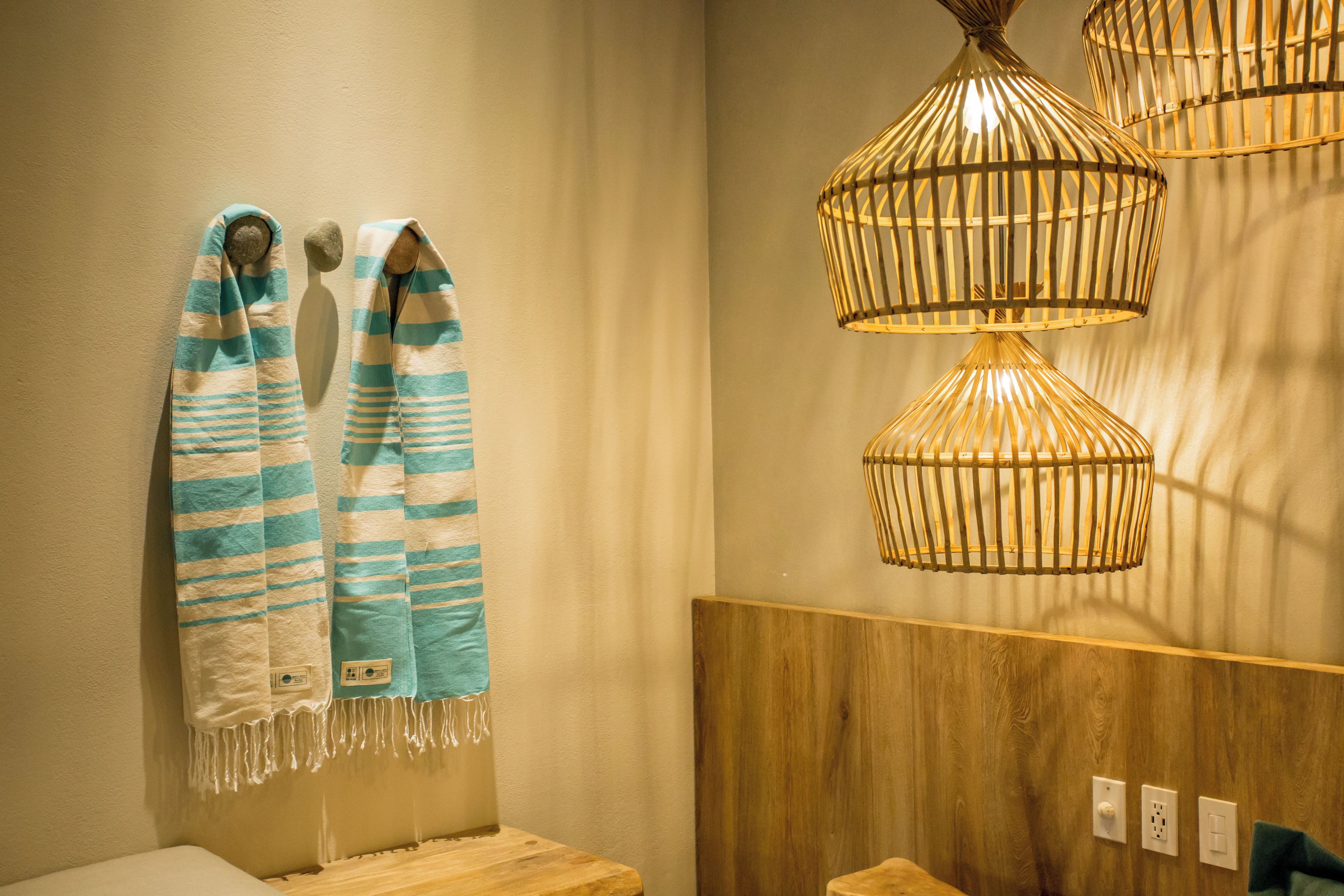 A bathroom with striped towels, wooden headboards, and a wooden wall.