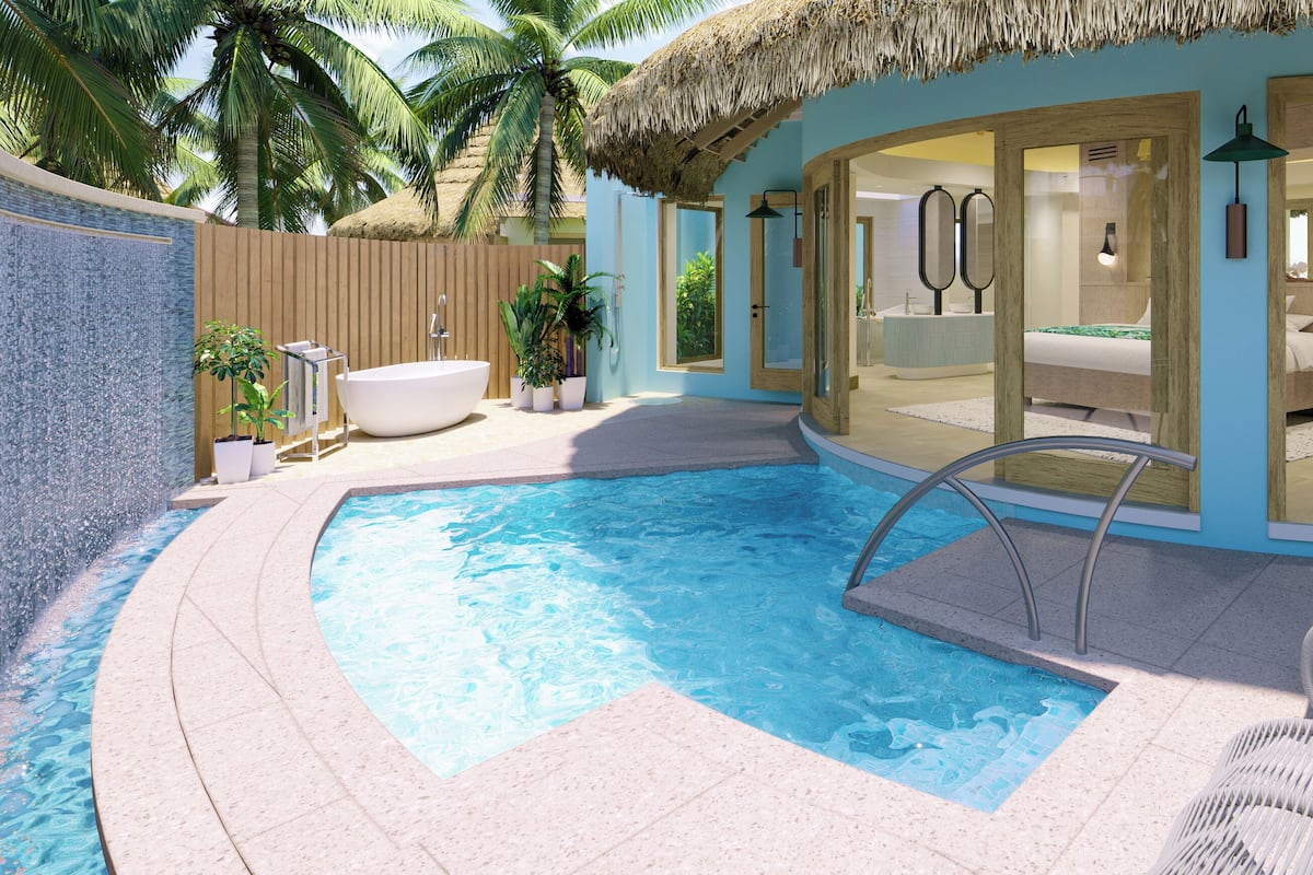 A swimming pool with a thatched roof, a spa area, and a beach chair.