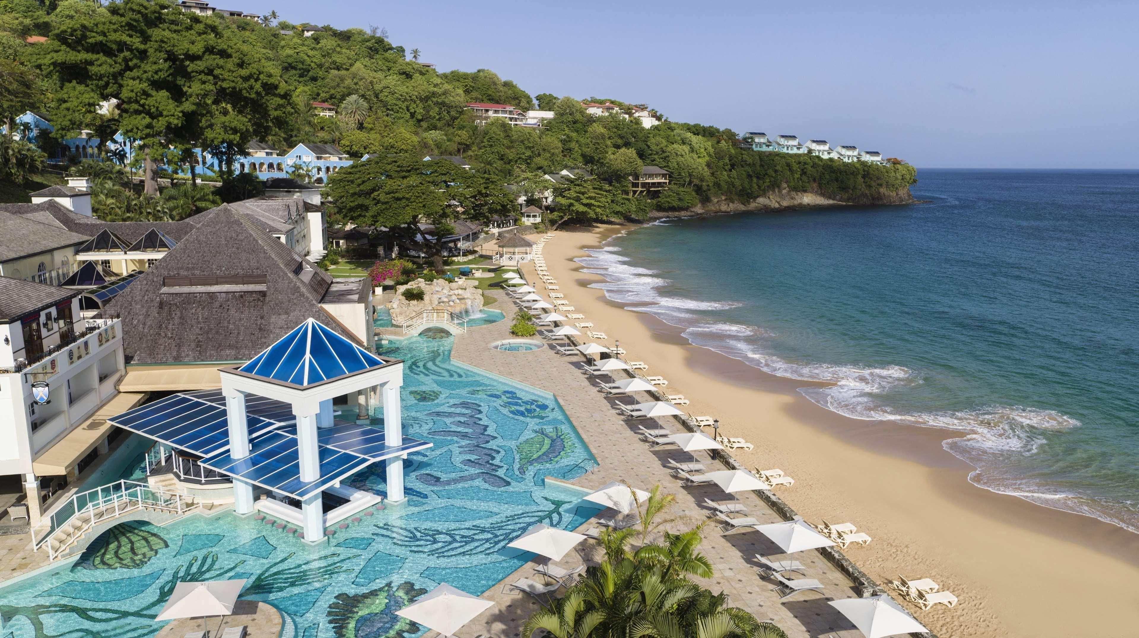 A resort with a swimming pool, beach, and ocean views.