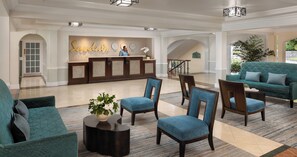 A lobby with a reception desk, seating area, and a staircase. - Sandals Regency La Toc (Castries)