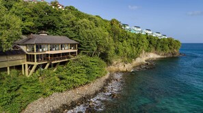 A coastal property with a house on stilts, a balcony, and a view of the sea. - Sandals Regency La Toc (Castries)