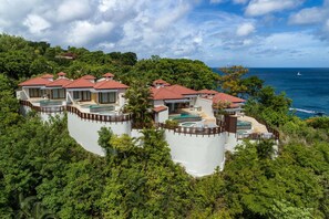 Un resort con diverse ville, ognuna dotata di piscina e circondata da vegetazione lussureggiante.