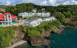 A coastal resort with multiple buildings, a swimming pool, and rocky cliffs. - Sandals Regency La Toc (Castries)