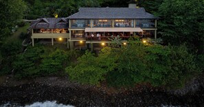 A multi-story resort with outdoor dining areas and a view of the surrounding forest.