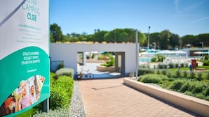 A sign for the Istra Camping Club with a pathway leading to a modern building.