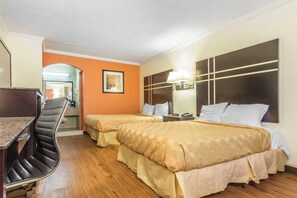 Una habitación de hotel con dos camas, un escritorio y una silla.