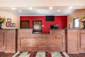 A reception area with a wooden reception desk, a red wall, and a door marked "Office". - Econo Lodge Gadsden Area (Grant)