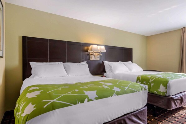 A hotel room with two beds, a headboard, a wall-mounted lamp, and a patterned bedspread. - Econo Lodge Gadsden Area (Grant)