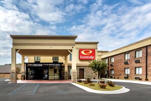 A hotel entrance with a covered area, a parking lot, and a landscaped garden. - Econo Lodge Gadsden Area (Grant)
