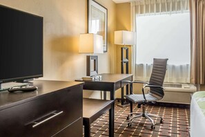 A hotel room with a flat-screen TV, a desk with a lamp, a chair, and a bed. - Econo Lodge Gadsden Area (Grant)