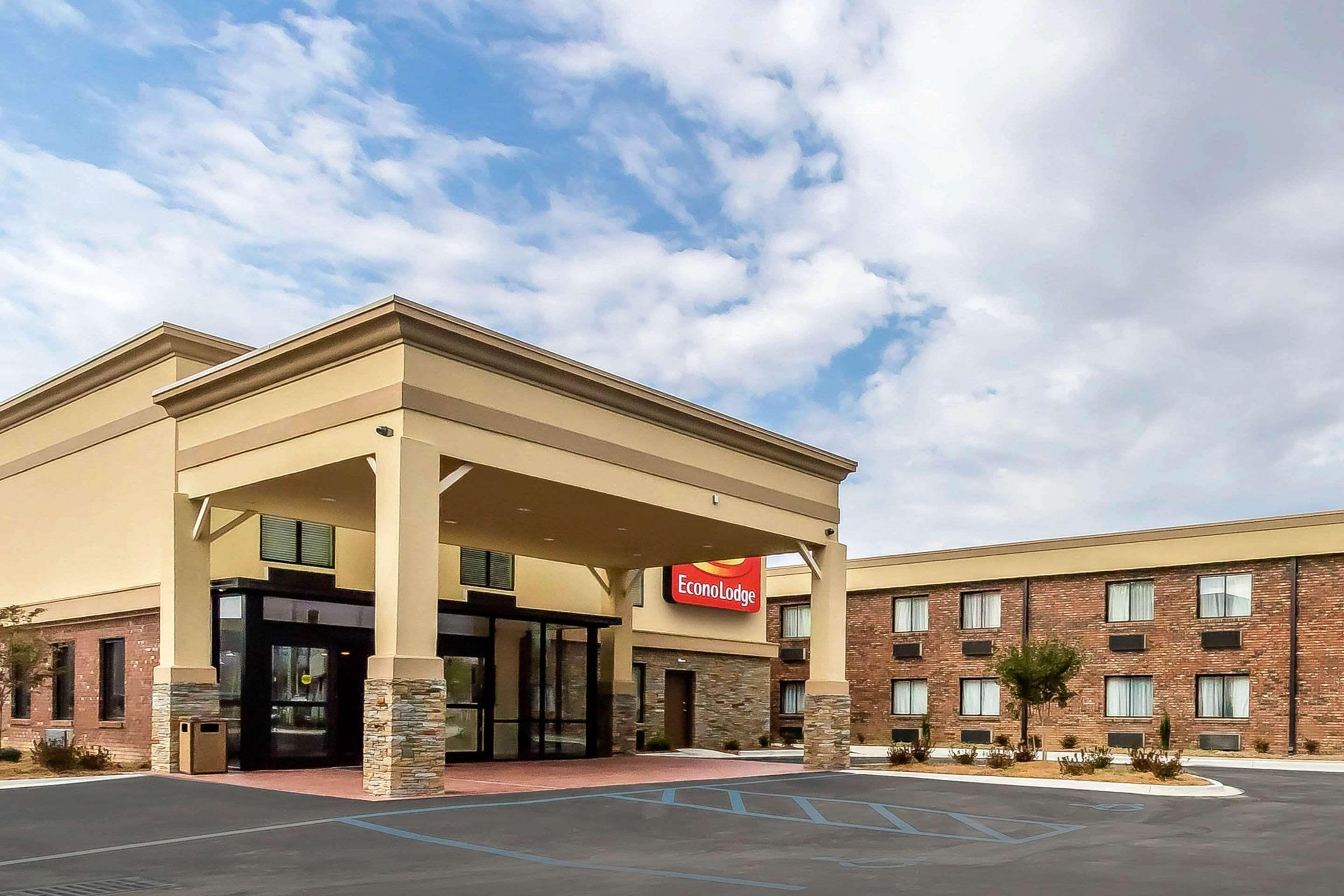 A hotel with a modern design, featuring a prominent entrance with a covered area and a sign for EconoLodge.