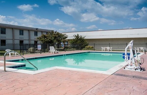 A swimming pool with a tiled deck, a lifeguard stand, and lounge chairs. - Suburban Studios Chester I-95 (Chester)