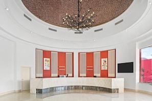 A reception area with a curved marble counter, a brick-patterned ceiling, and a modern chandelier. - Pickalbatros Laguna Club (Sharm El Sheikh)