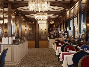 A restaurant interior with a long counter, multiple chandeliers, and tables set for dining. - Botel Albatros (Prague)