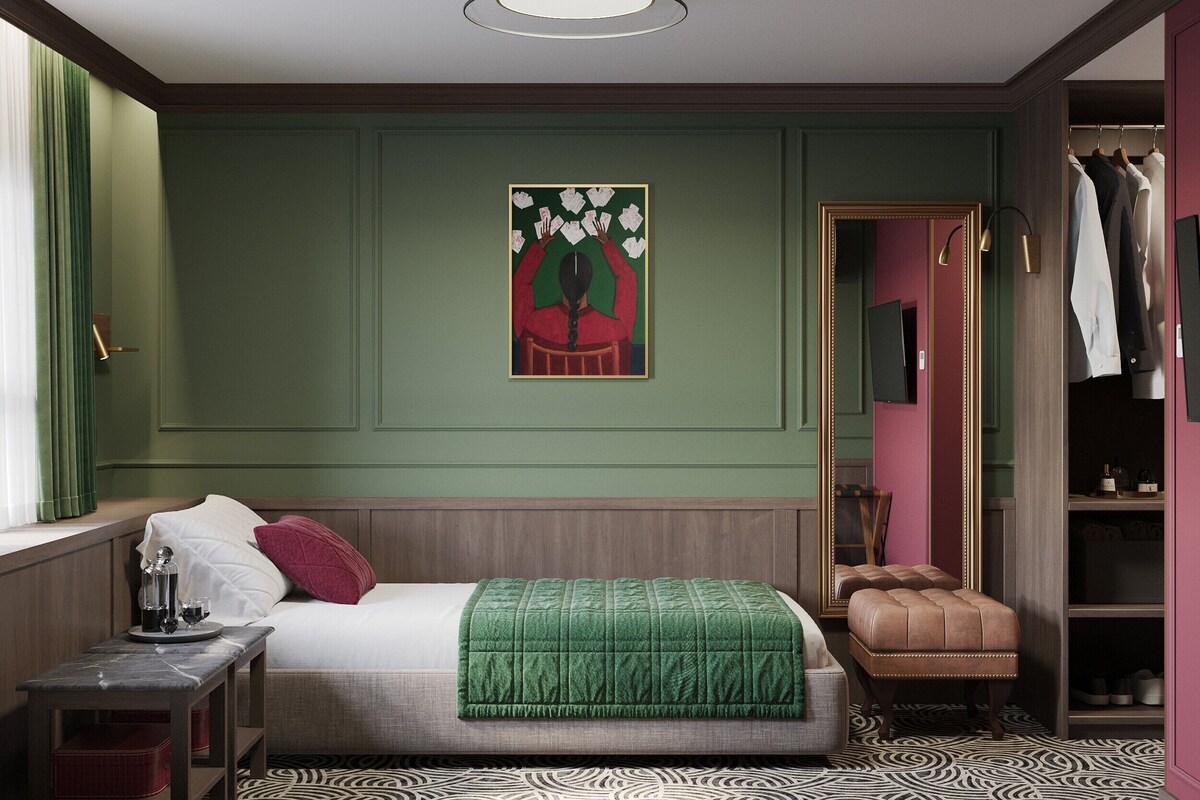 Un dormitorio con cama, mesita de noche, un cuadro de arte en la pared color verde y un armario.
