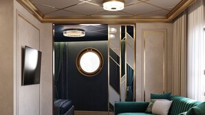 A room with a green sofa, a round mirror, a chandelier, and a patterned carpet. - Botel Albatros (Prague)