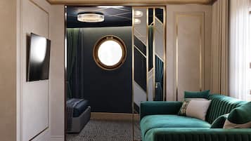 Ein Zimmer mit einem grünen Sofa, einem runden Spiegel, einer Chandelierleuchtre und einem gemusterten Teppich.