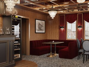 A restaurant interior with a wooden panel wall, a red velvet sofa, a table with chairs, and a chandelier. - Botel Albatros (Prague)