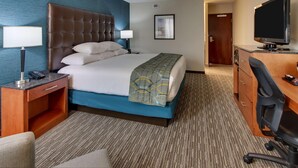 A hotel room with a large bed, a desk with a computer, a TV, and a chair. - Pear Tree Inn Airport St. Louis - St. Ann (St. Ann)