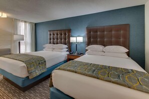A hotel room with two beds, a nightstand, a lamp, and a window with curtains. - Pear Tree Inn Airport St. Louis - St. Ann (St. Ann)