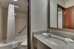 A bathroom with a shower, toilet, sink, and mirror. - Pear Tree Inn Airport St. Louis - St. Ann (St. Ann)